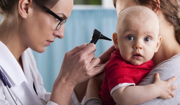 Child's otolaryngologist doing ear examination of infant