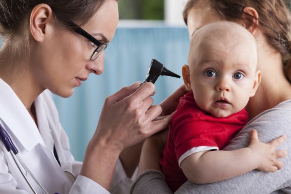Child's otolaryngologist doing ear examination of infant